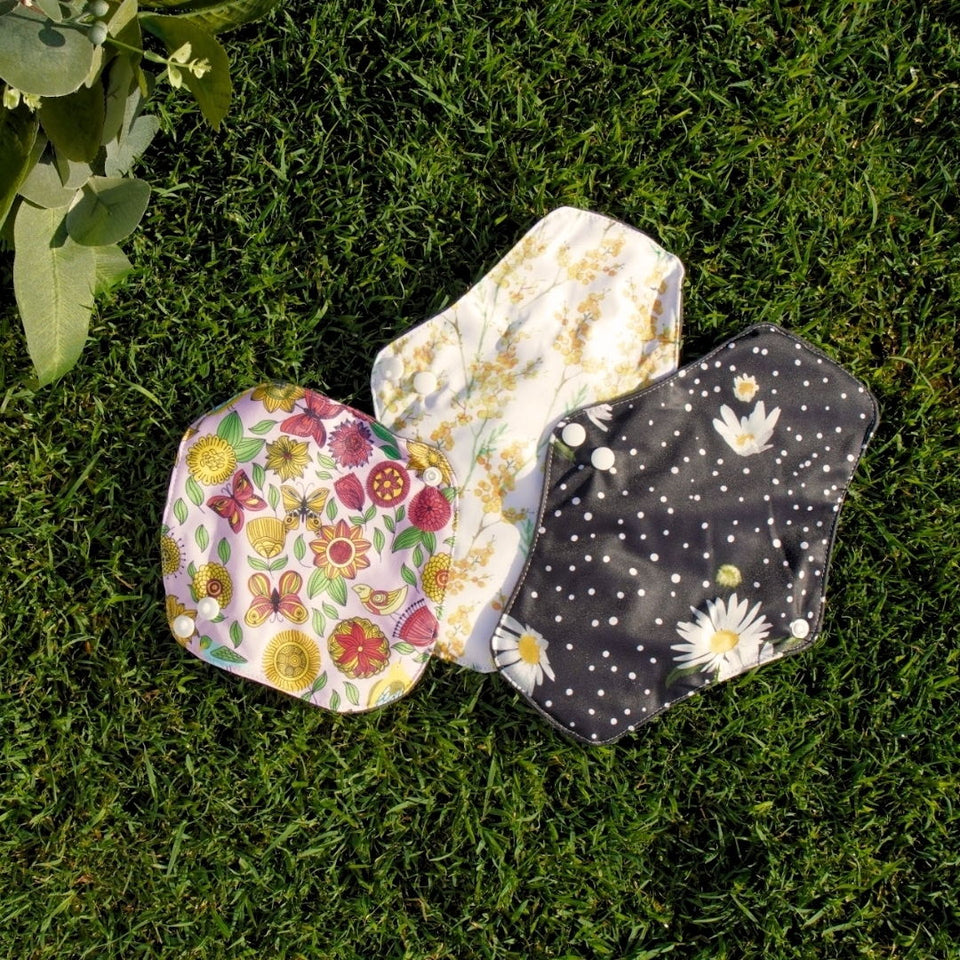 Three Flow Co reusable pads laid on grass
