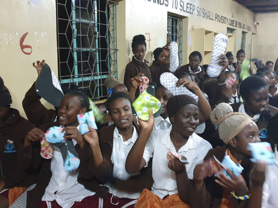 A group of students holding up Flow Co reusable pads