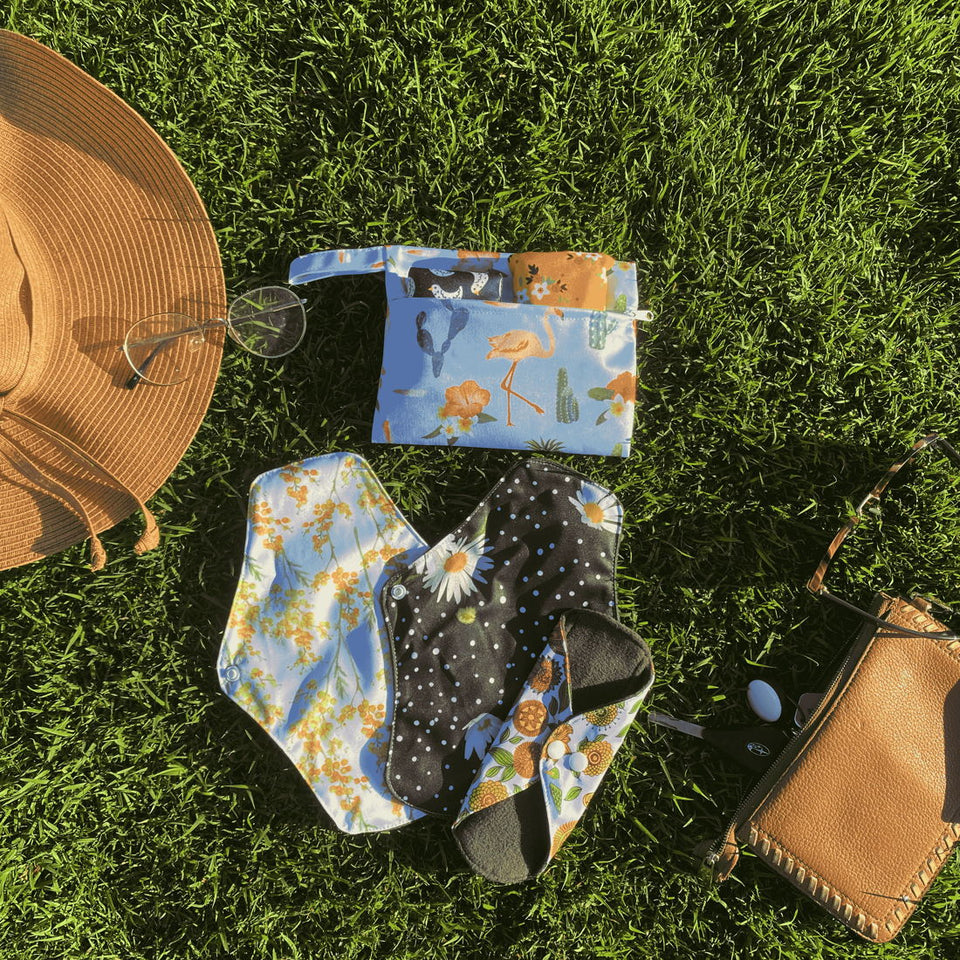 Flow Co pads and a wet bag laid out on grass